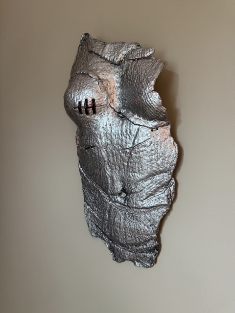 Kvinne/Torso – Sølv av Anne Holter: sølvfarget keramikktorso med sår og arr